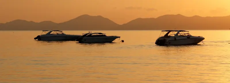 Yacht vor einer abendlichen Inselküste